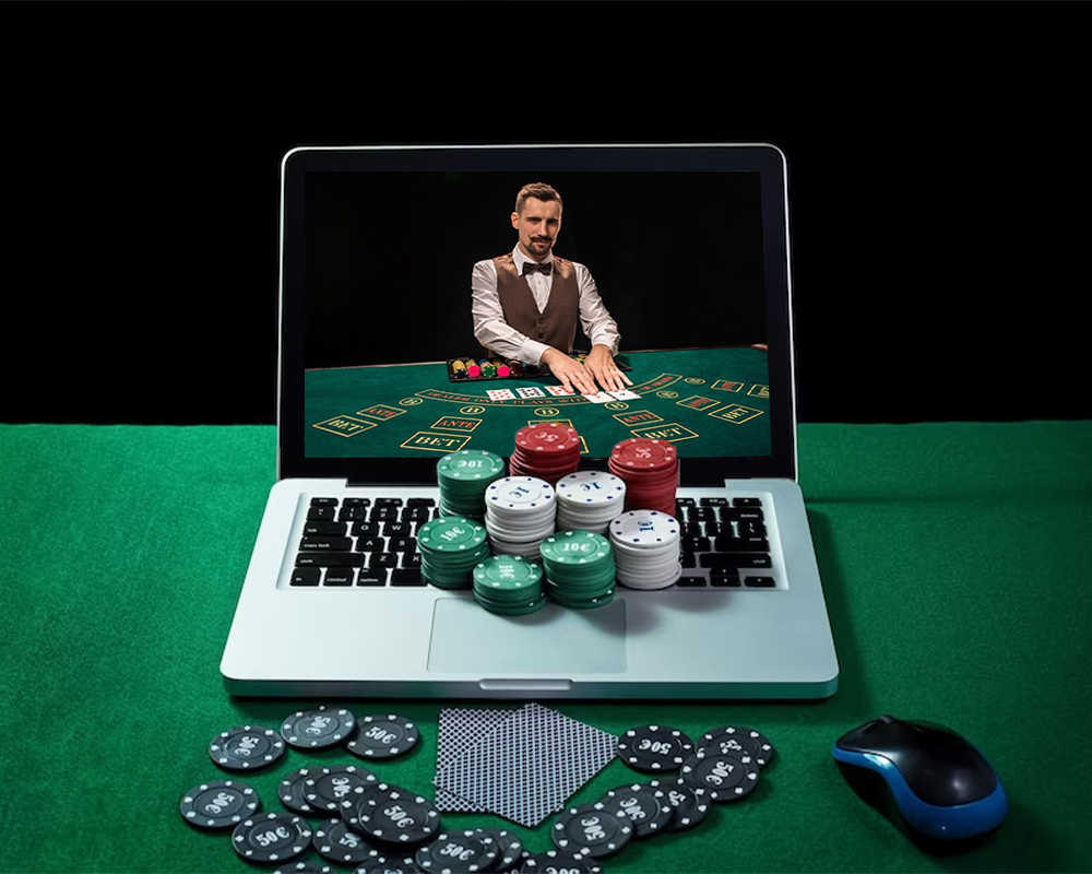 A laptop showing a dealer in an online casino, casino chips on keypad - How to Play Casino Games - thegamerian.com Gaming Blog 